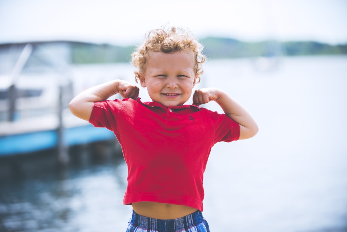 Child flexing at the dock, a candid everyday moment