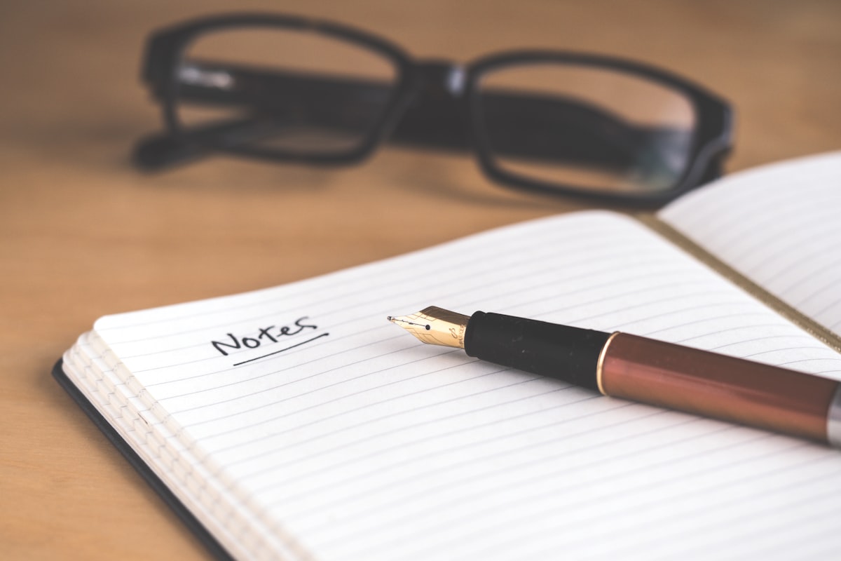 Open journal with fountain pen and glasses